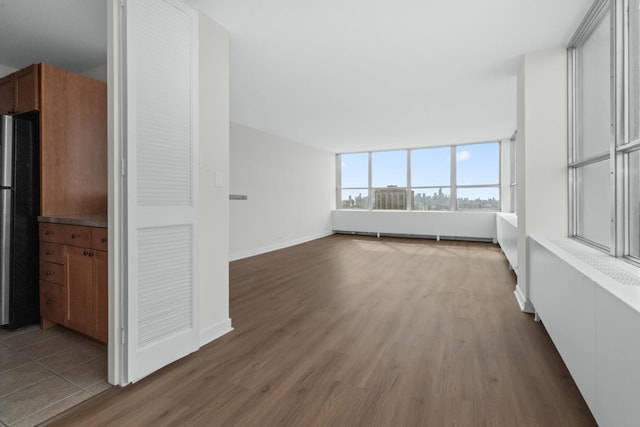 655 W Irving Park Rd Unit 4417, Chicago, IL 60613 - unfurnished living room featuring baseboards and wood finished floors