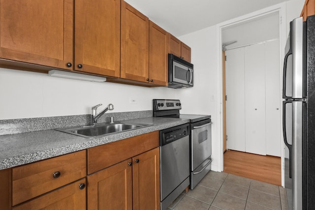 655 W Irving Park Rd Unit 4417, Chicago, IL 60613 - kitchen with tile patterned flooring, a sink, brown cabinetry, and stainless steel appliances