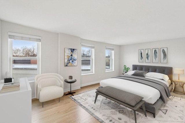 bedroom with baseboards and light wood finished floors