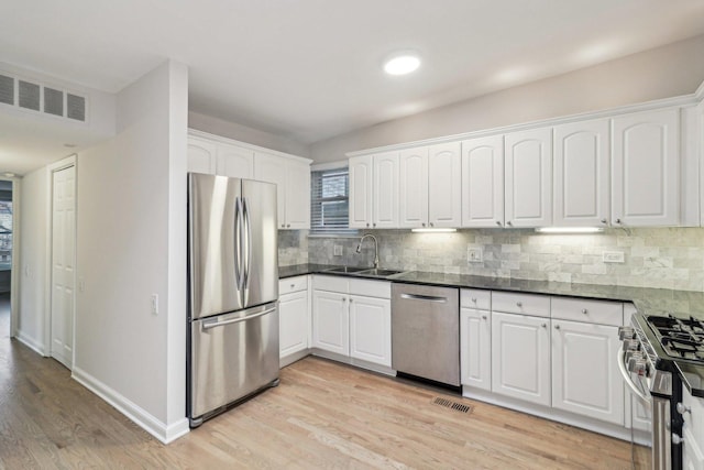 kitchen with stainless steel appliances, visible vents, a sink, and light wood-type flooring