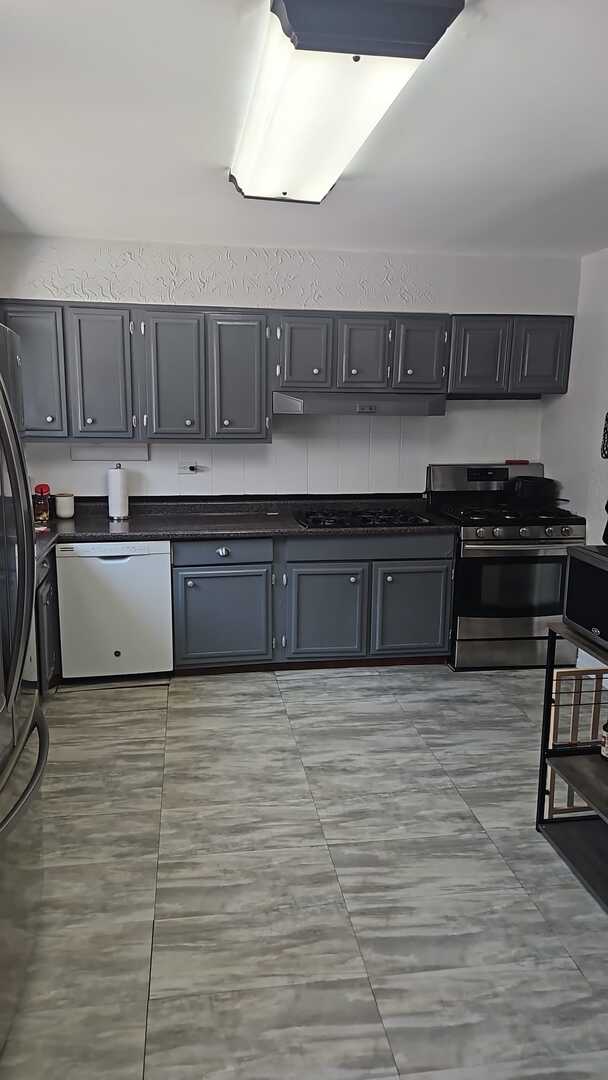 7013 W Greenleaf Ave, Niles, IL 60714 - kitchen with dark countertops, stainless steel gas range oven, black fridge, and dishwasher