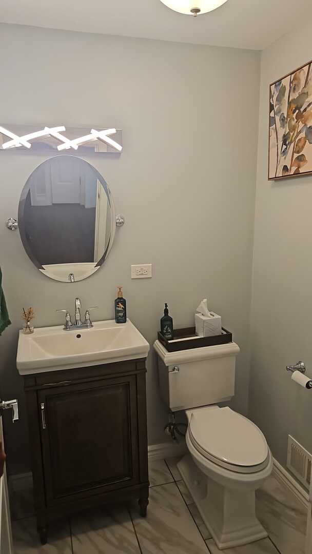 7013 W Greenleaf Ave, Niles, IL 60714 - bathroom with visible vents, baseboards, toilet, and vanity