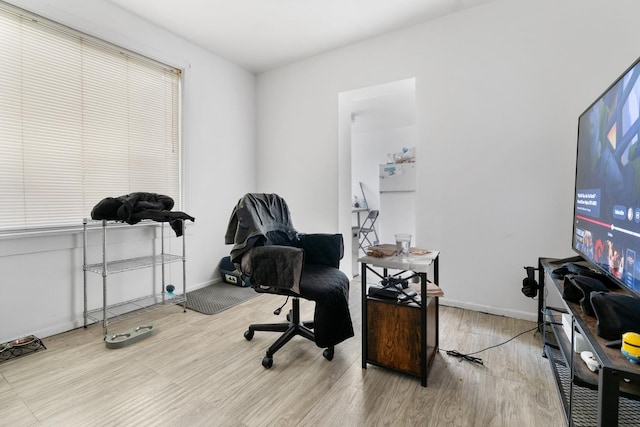 home office with baseboards and wood finished floors