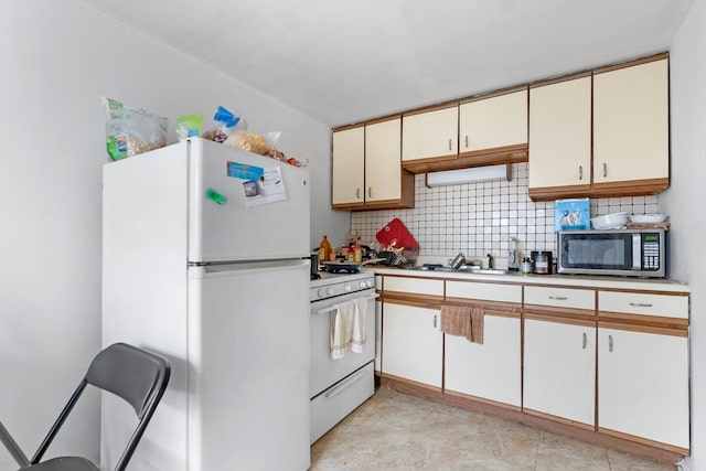 kitchen with white appliances, a sink, cream cabinetry, backsplash, and light countertops