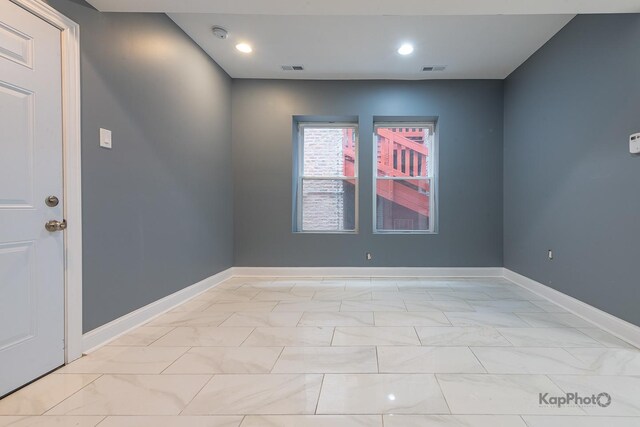 empty room featuring baseboards, marble finish floor, recessed lighting, and visible vents
