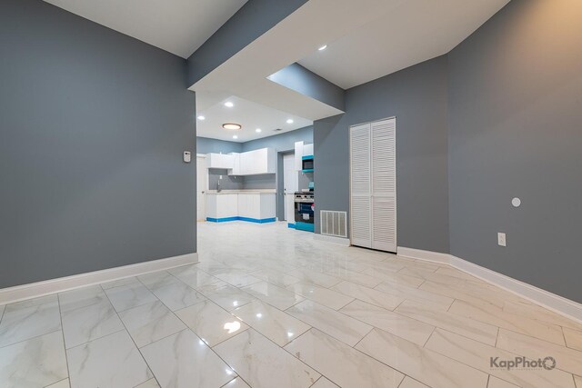 unfurnished room with visible vents, a sink, and baseboards