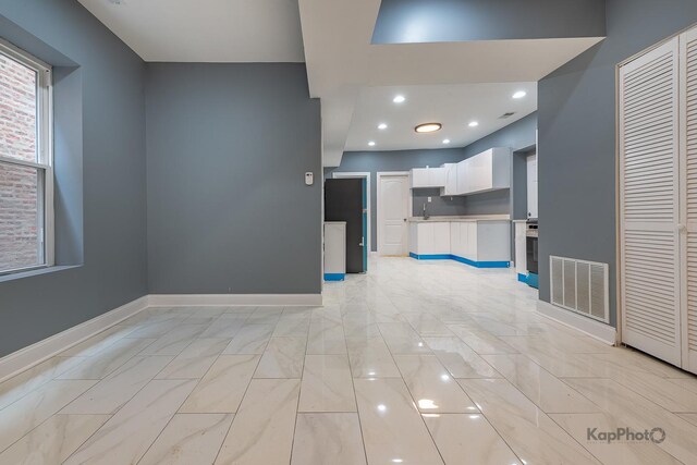 interior space featuring visible vents, recessed lighting, baseboards, and a sink