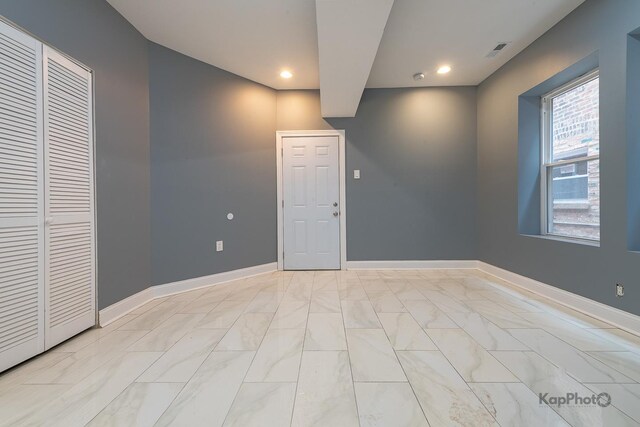 unfurnished room featuring baseboards, marble finish floor, recessed lighting, and visible vents