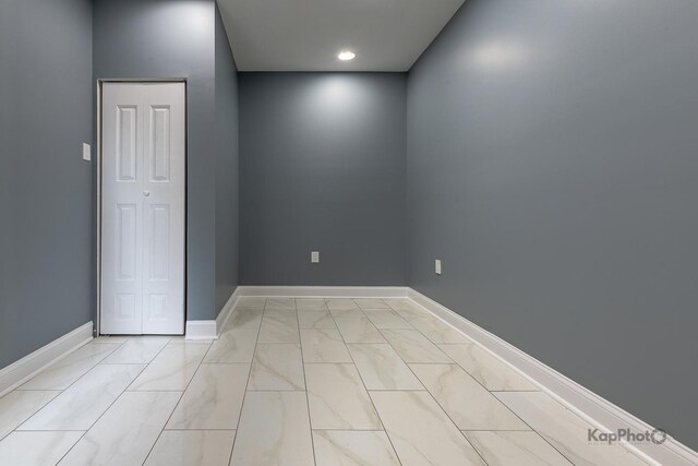 unfurnished room featuring baseboards and marble finish floor