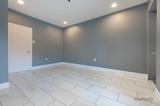 spare room with recessed lighting and baseboards