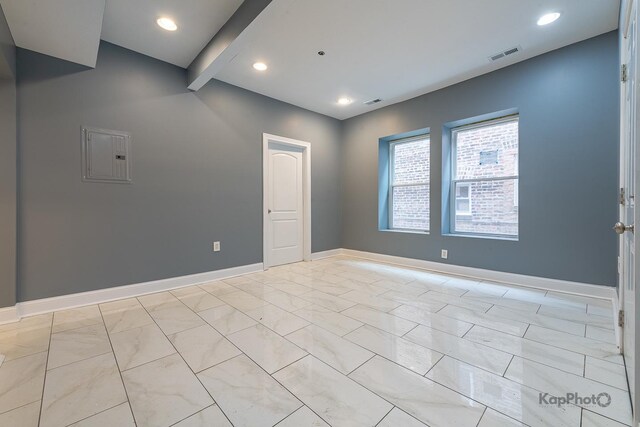 spare room with visible vents, beamed ceiling, baseboards, recessed lighting, and electric panel