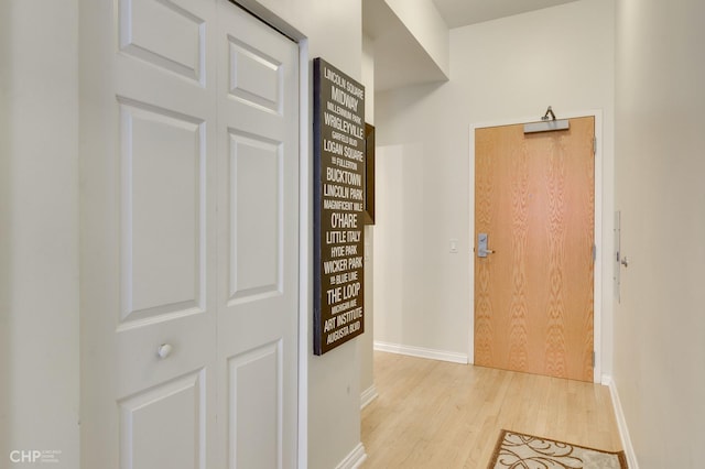 corridor with baseboards and wood finished floors