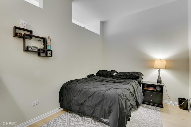 bedroom with baseboards and wood finished floors