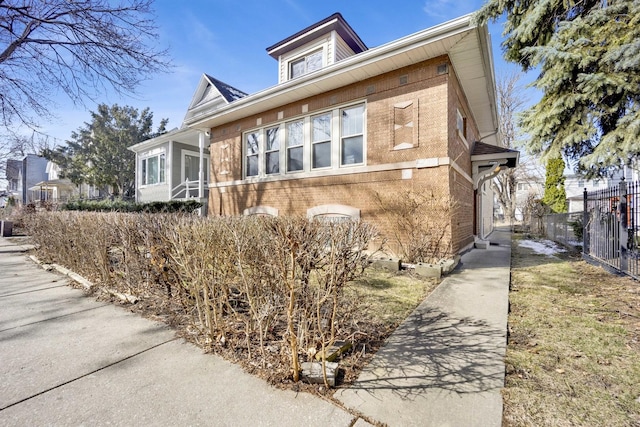 view of front of house featuring brick siding and fence