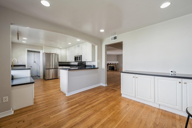 1578 Mccraren Rd, Highland Park, IL 60035 - kitchen with stainless steel appliances, dark countertops, a sink, white cabinetry, and recessed lighting