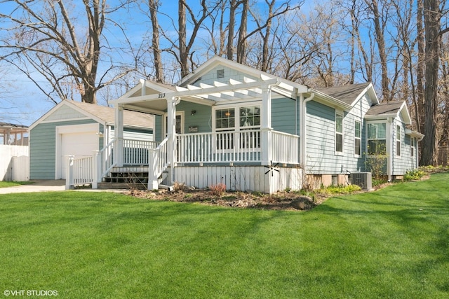 view of front of property featuring a porch, driveway, a front yard, an outbuilding, and cooling unit