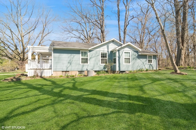 rear view of property featuring a lawn, covered porch, and cooling unit