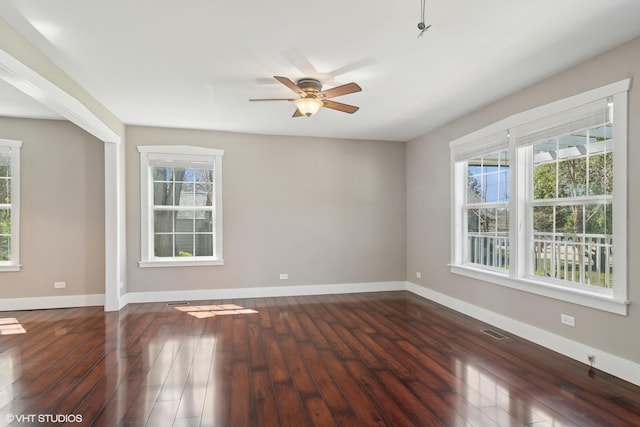 spare room featuring baseboards, ceiling fan, hardwood / wood-style flooring, and visible vents
