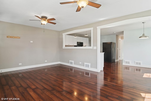 unfurnished living room featuring visible vents, dark wood finished floors, ceiling fan, and baseboards