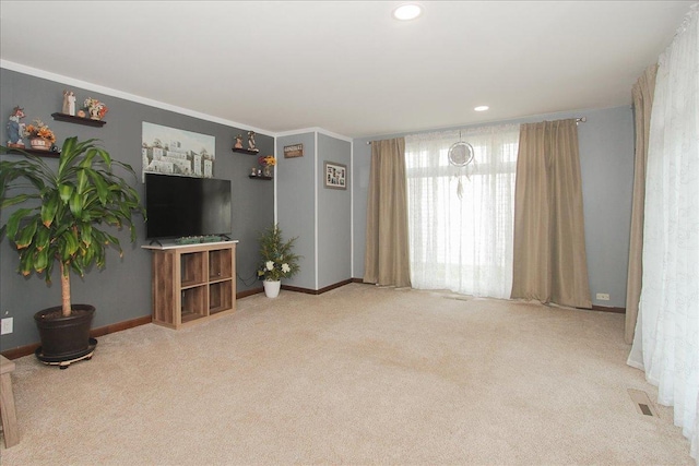 unfurnished living room featuring visible vents, baseboards, ornamental molding, carpet, and recessed lighting