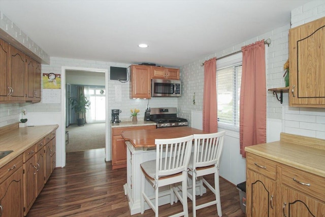 kitchen with appliances with stainless steel finishes, a wealth of natural light, and tasteful backsplash