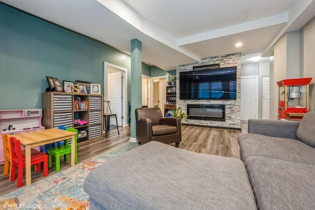 living area featuring recessed lighting, wood finished floors, and a large fireplace