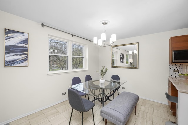 dining area with baseboards and a chandelier