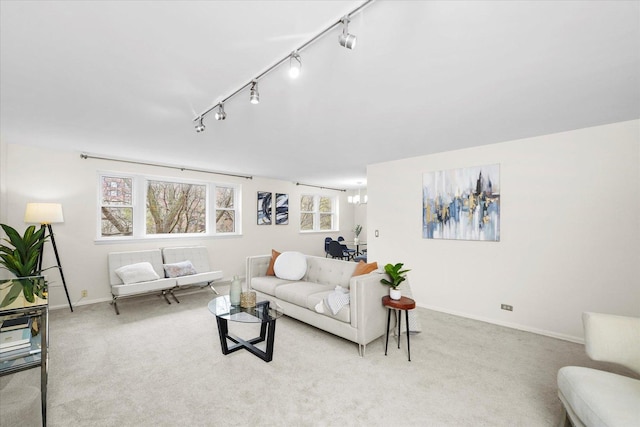 living area with carpet floors, baseboards, and track lighting