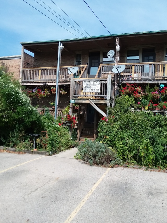 view of property with uncovered parking and stairway