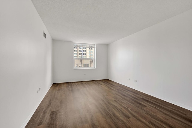 empty room featuring dark wood finished floors and baseboards