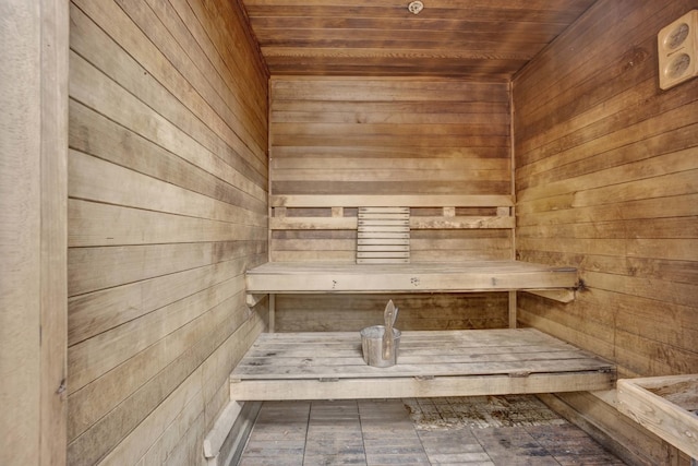 relaxing sauna featuring wooden ceiling and wooden walls