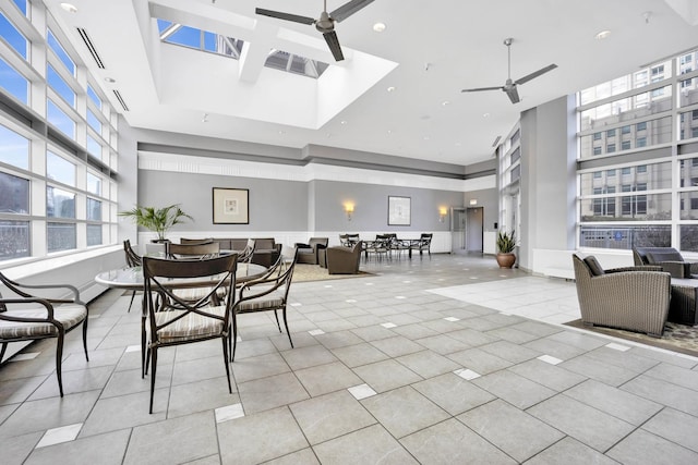 dining area with ceiling fan, a towering ceiling, light tile patterned flooring, and recessed lighting