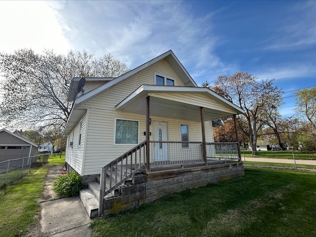 bungalow-style home featuring a porch, fence, and a front lawn