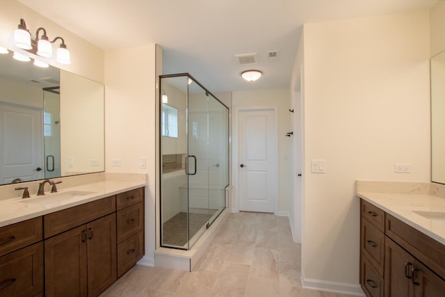 bathroom with a sink, baseboards, two vanities, visible vents, and a stall shower