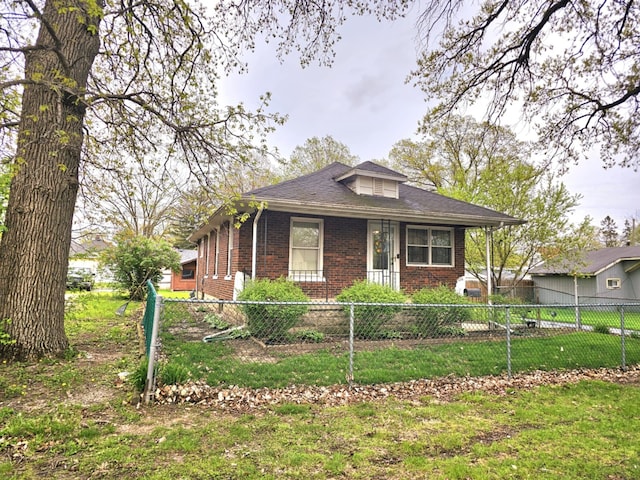 view of front of property featuring a fenced front yard, a front yard, and brick siding