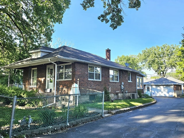 526 Osage St, Joliet, IL 60432 - bungalow-style house featuring a garage, a fenced front yard, brick siding, and a chimney