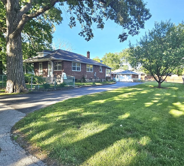 526 Osage St, Joliet, IL 60432 - view of front of home with brick siding, a chimney, a front yard, and driveway