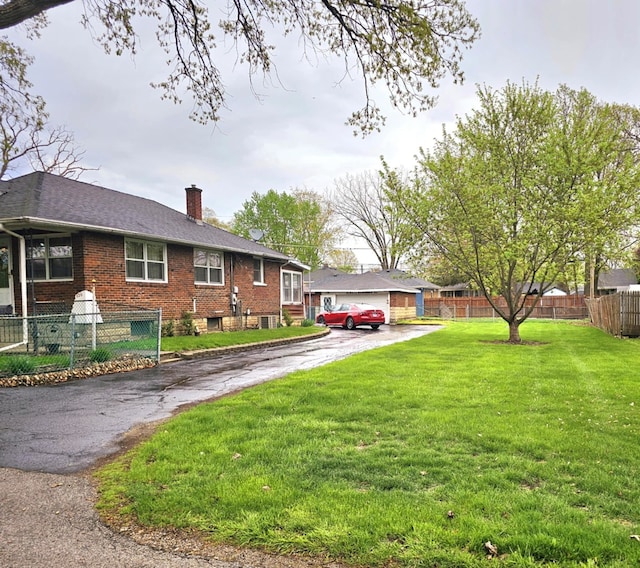 view of front of property featuring brick siding, a front lawn, fence, and a chimney