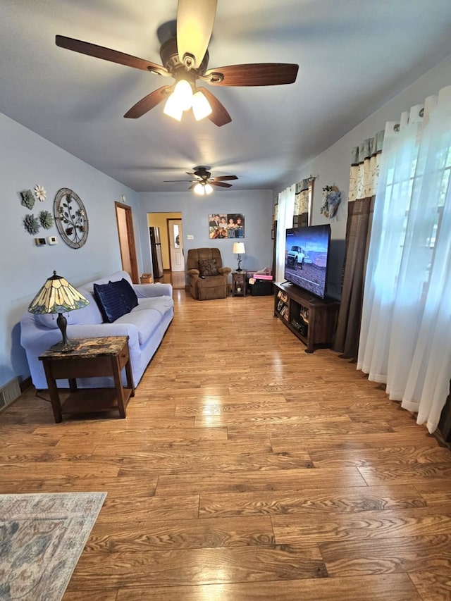 living room featuring ceiling fan, wood finished floors, and visible vents