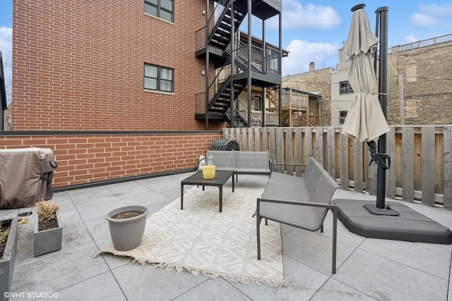 view of patio / terrace featuring fence, stairs, and a grill