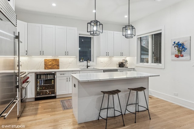 kitchen with a sink, high quality appliances, backsplash, and beverage cooler