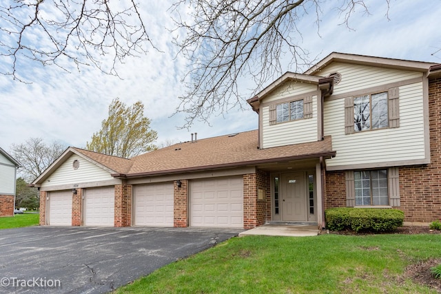 view of front of house featuring brick siding, an attached garage, driveway, and a front yard