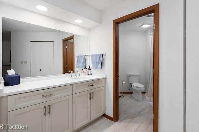 full bath featuring toilet, baseboards, recessed lighting, and vanity