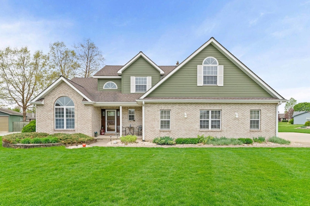 1026 Bauer Ct, Sandwich, IL 60548 - view of front facade featuring roof with shingles, brick siding, and a front yard