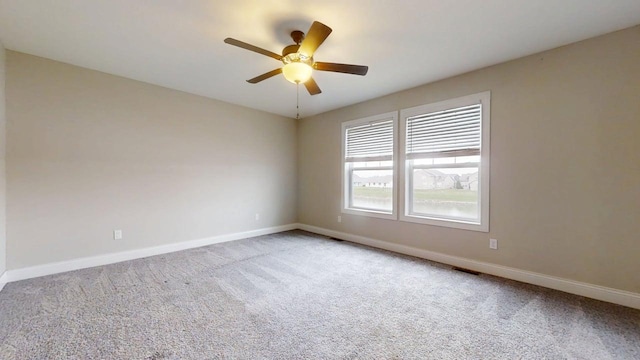 empty room featuring baseboards, visible vents, ceiling fan, and carpet