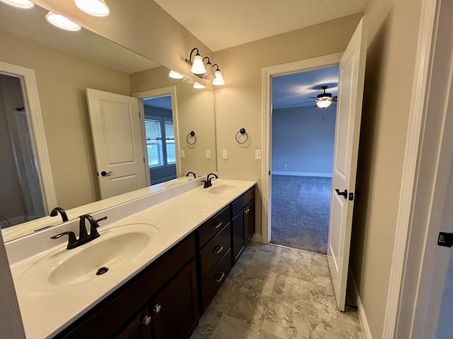 full bath featuring a sink, baseboards, ceiling fan, and double vanity