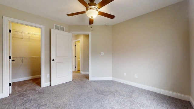 unfurnished bedroom with visible vents, baseboards, a closet, a spacious closet, and carpet flooring