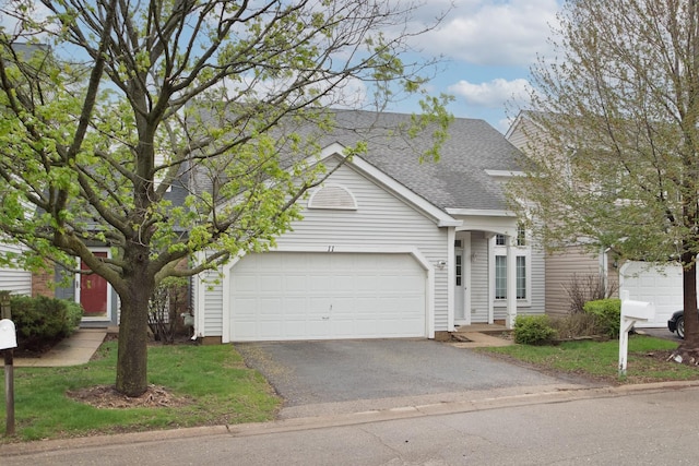 view of front of house with a garage, a shingled roof, and driveway