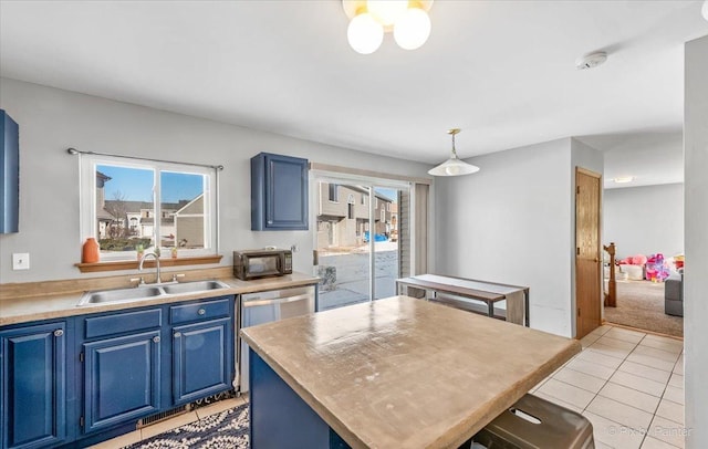 kitchen featuring a sink, light tile patterned flooring, black microwave, a center island, and blue cabinets