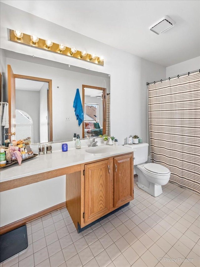 bathroom with vanity, tile patterned floors, toilet, and a shower with curtain